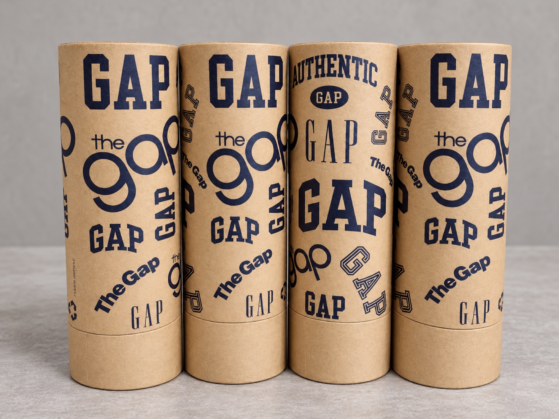 Four completed cylindrical kraft tubes with dark-blue branded artwork