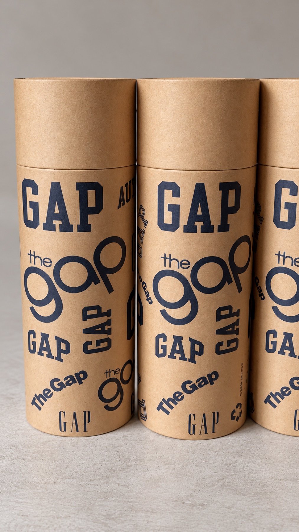 Three finished branded cylindrical kraft tubes grouped for inspection